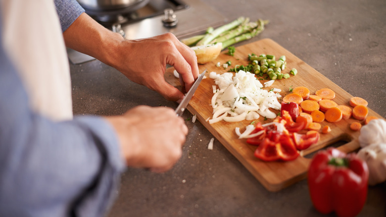 Person chopping vegetables on cutting board