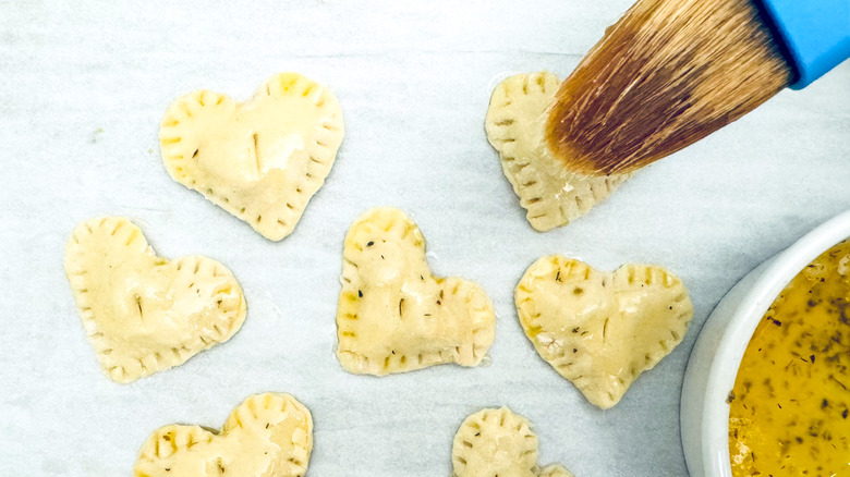 brushing butter on pastry hearts