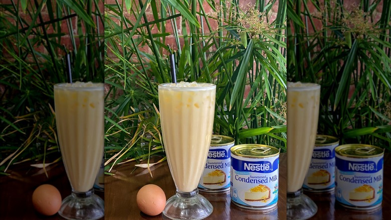 Vietnamese egg soda in glass with egg and condensed milk on table