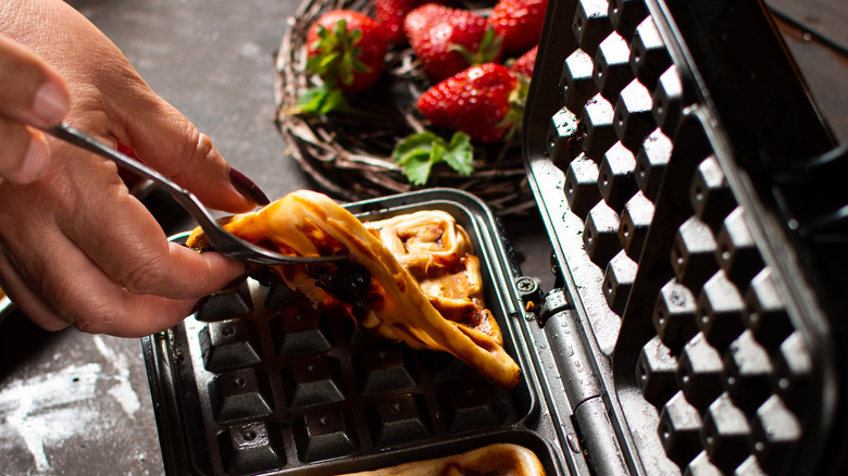 French toast in waffle iron with strawberries on the side