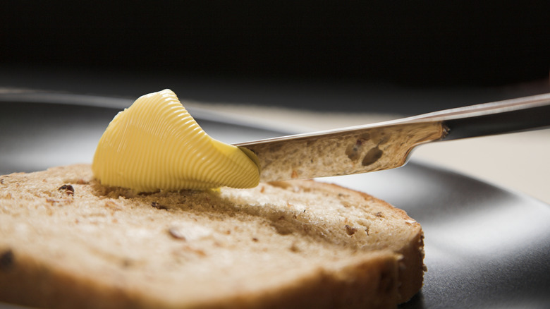 Margarine being spread on bread