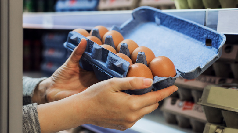 person holding open egg carton 