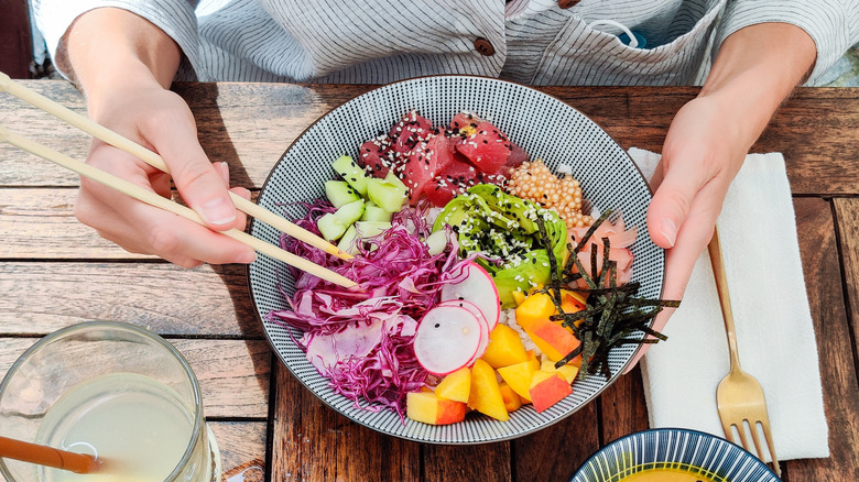 person eating a poke bowl