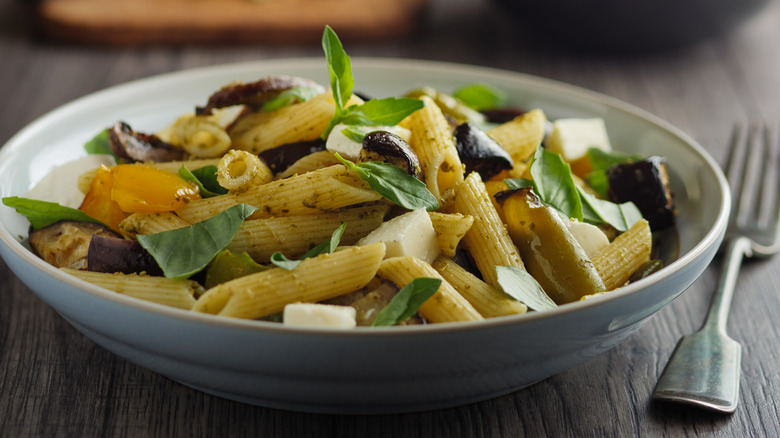 Bowl of pasta salad with veg feta and herbs