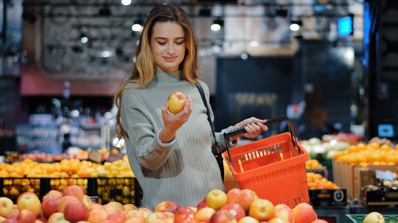 woman buying apples at store