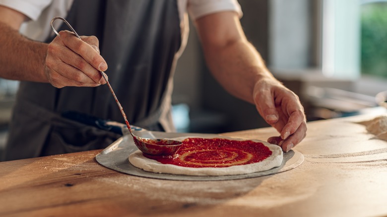 Spreading sauce on pizza dough