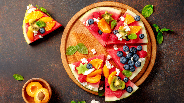 Watermelon pizza on a wooden plate