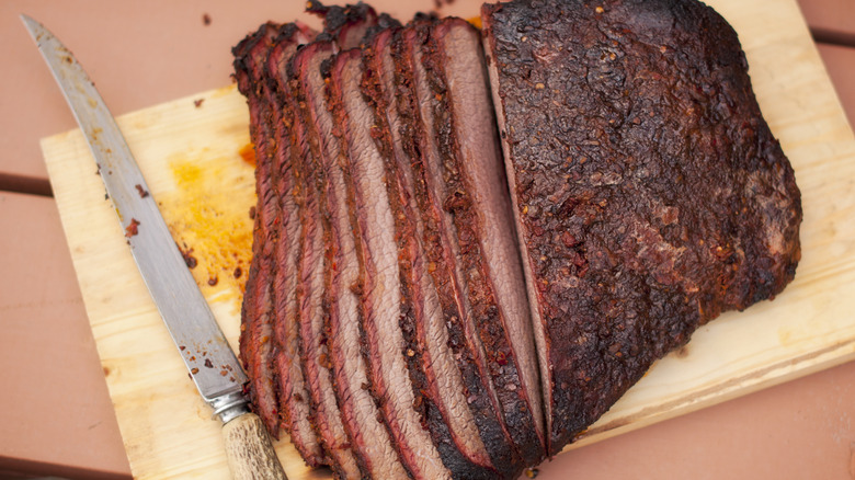 Smoked beef brisket sliced on a wooden board.