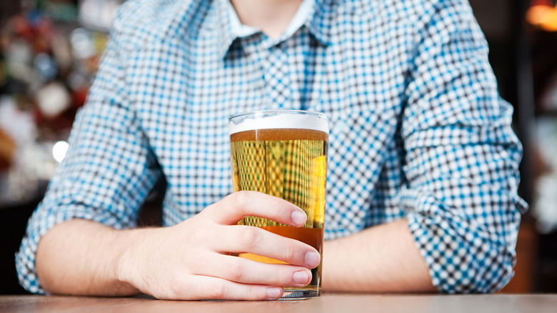 Man holding pint of beer