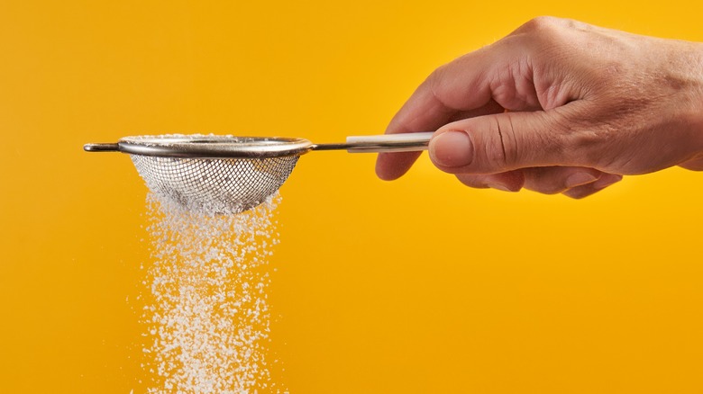 Person sifting powdered sugar