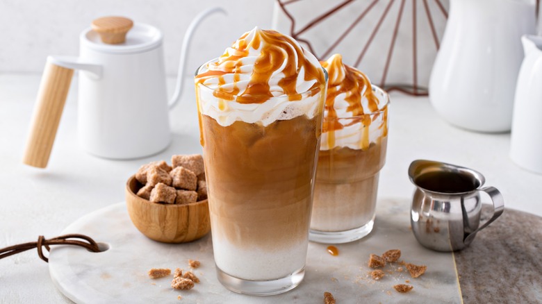 coffee in glass tumblers caramel and whipped cream toppings
