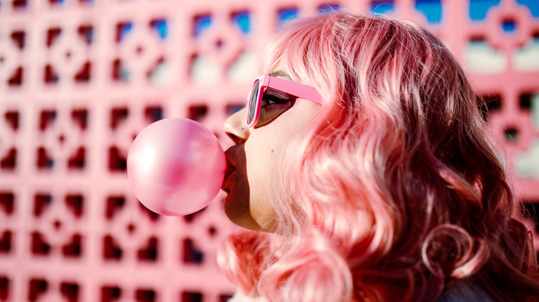 pink haired woman blowing bubble gum