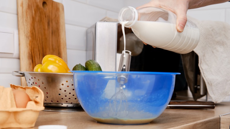 Pouring cream into scrambled eggs