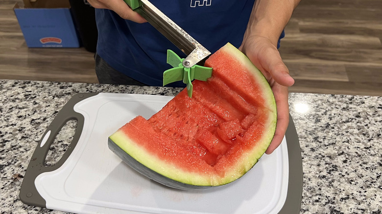 person cutting edge of watermelon