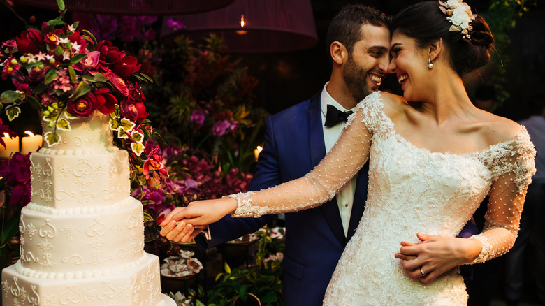 Bride and groom cutting wedding cake