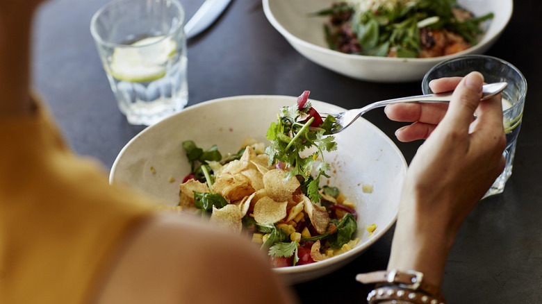 person eating salad with fork