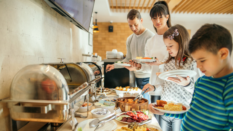 family taking food from continental breakfast buffet