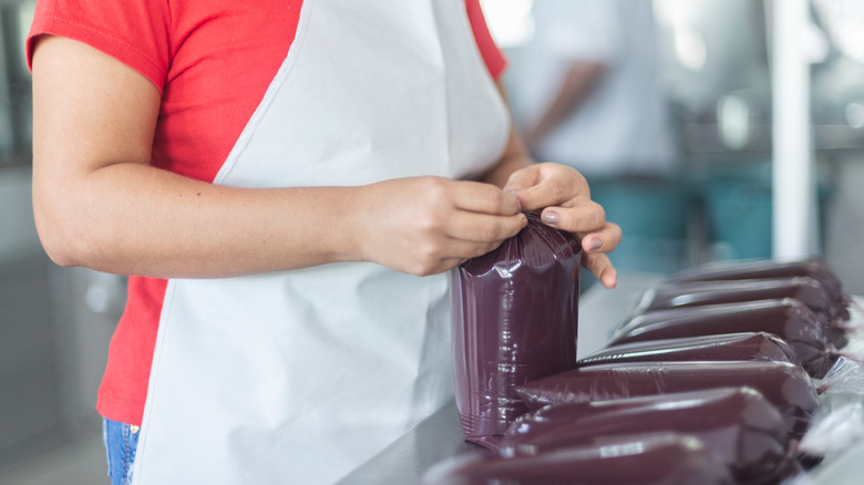 Person tying bag of acai puree