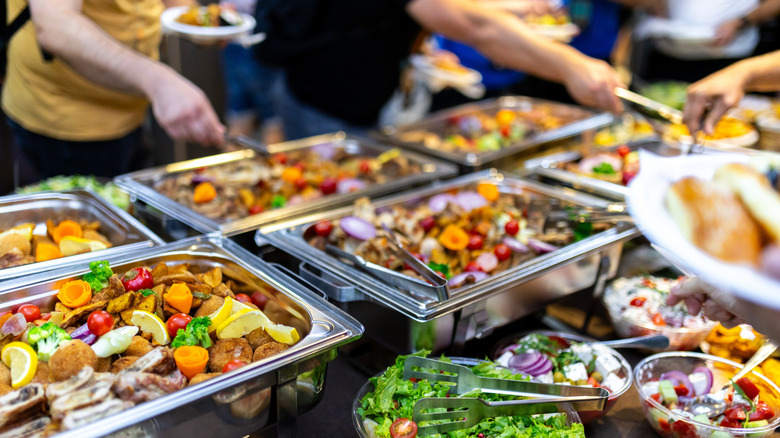 People serving themselves from buffet trays