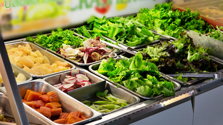 A buffet salad bar with a selection of vegetables