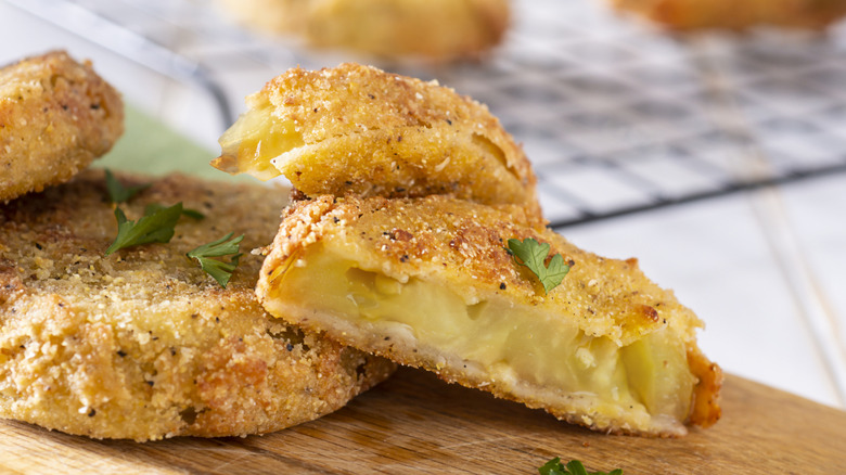 Stacked fried green tomato slices with crosscut showing interior of a slice