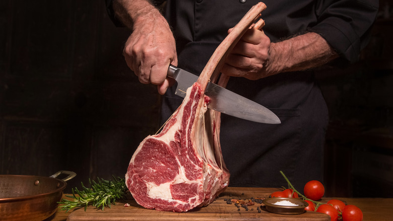 A chef cutting ribs into steaks