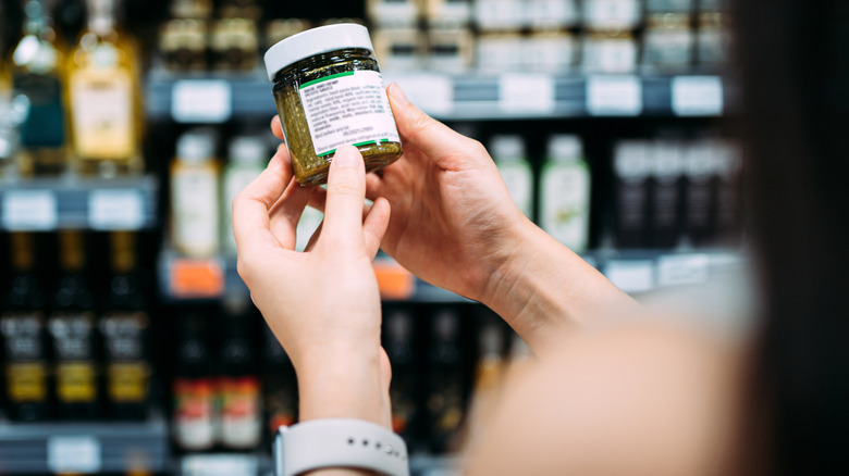 Customer holding can of chiles in grocery store