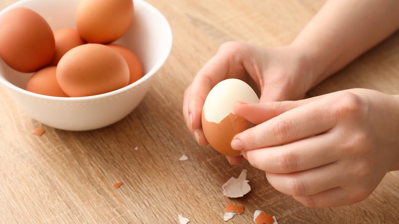 Person peeling a boiled egg