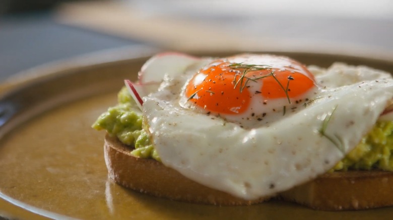 Richly colored heirloom egg on avocado toast