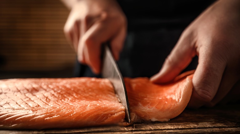 someone cutting salmon