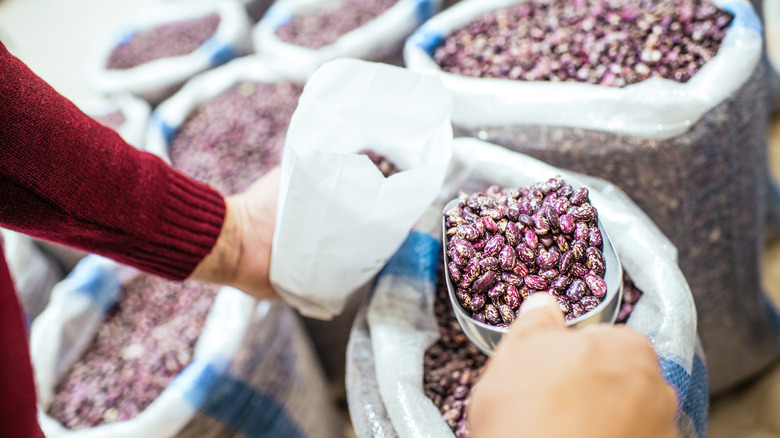 person scooping beans at store