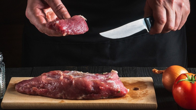 Cutting meat with boning knife