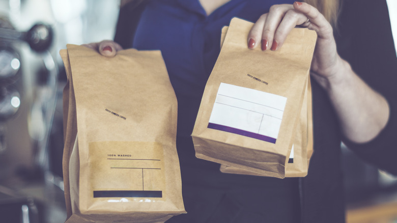 woman holding bags of coffee beans