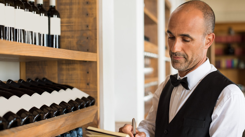 Restaurant server at wine shelf