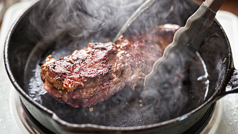 steak cooking in skillet