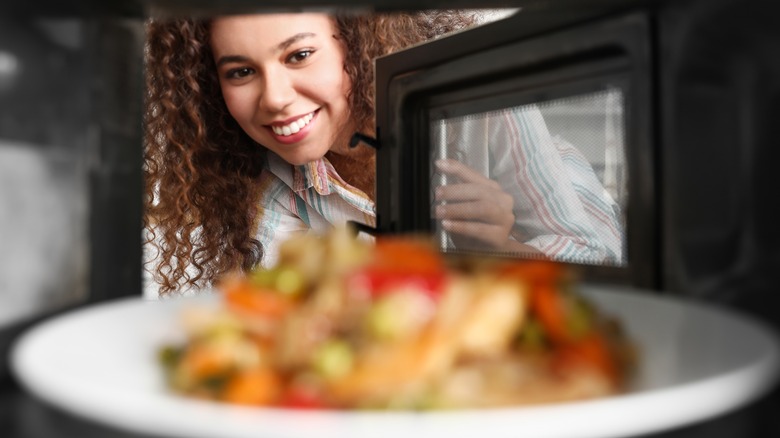 Woman smiles at microwaved food