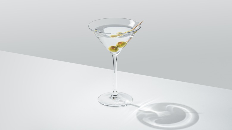 Classic martini with olives on white table