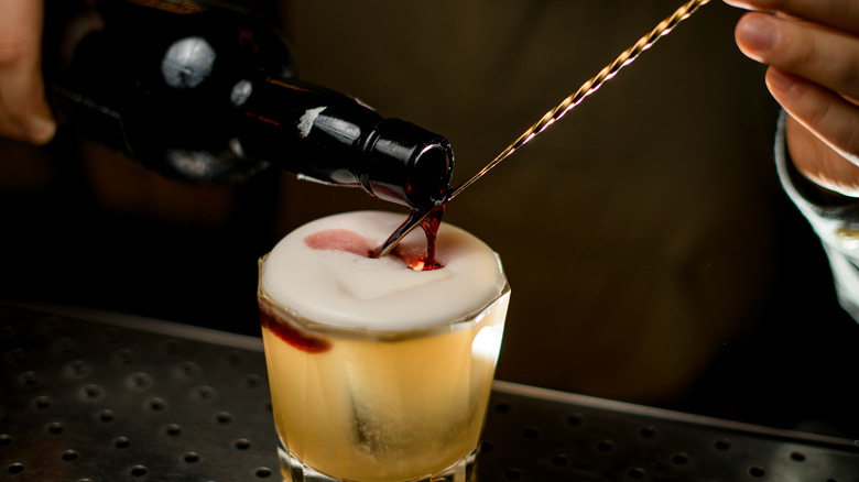 wine being floated on the top of a cocktail