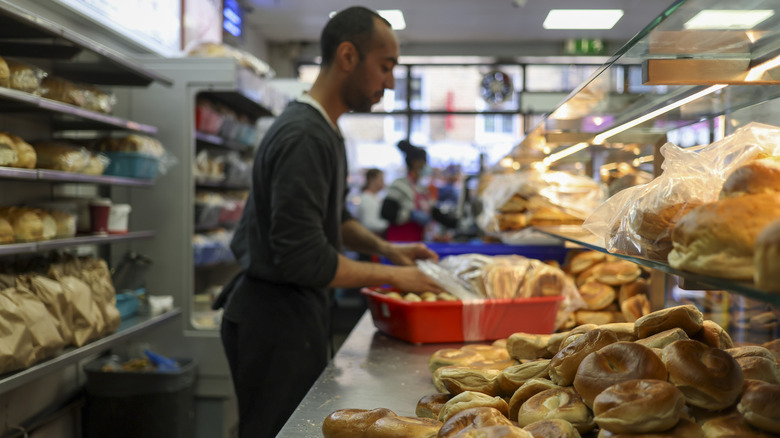 Employee at bagel shop works behind counter