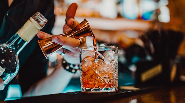 Pouring liquor into cocktail glass