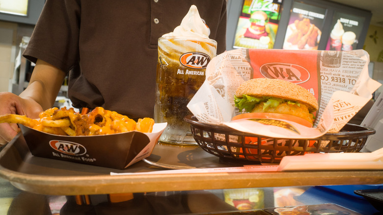 Employee holding tray with A&W food 