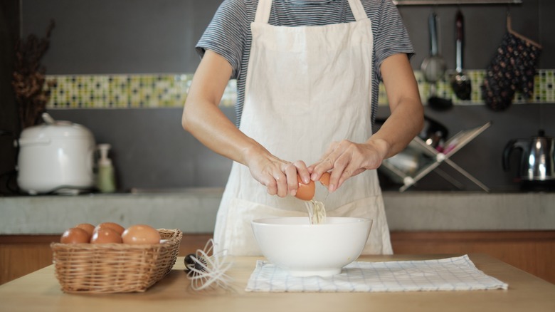 Person cracking egg into bowl