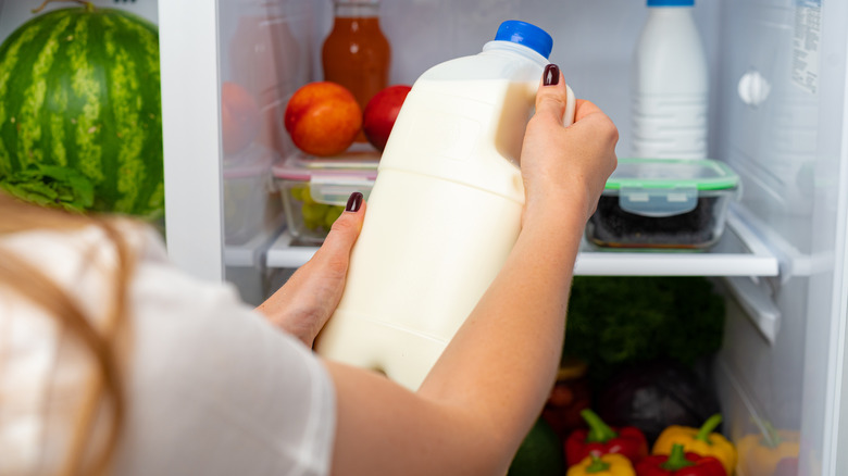 Woman taking milk from fridge