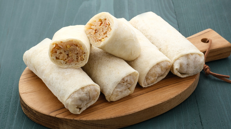 Five unfried lumpia on cutting board