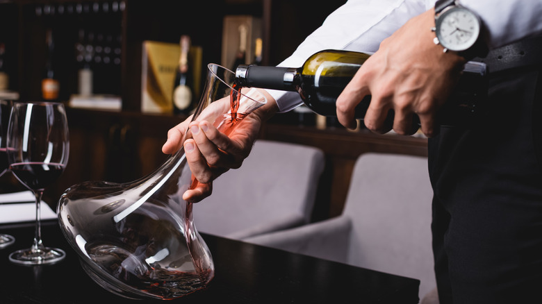 Waiter pouring red wine into a decanter