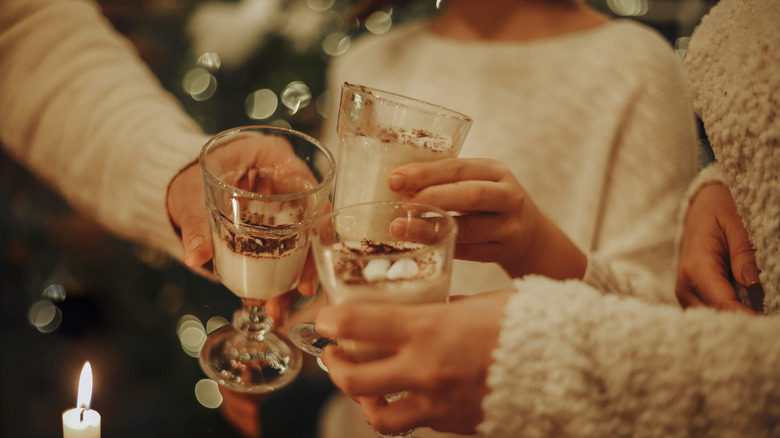 People toasting cups of eggnog at a holiday party