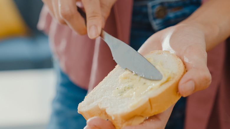 Person buttering bread