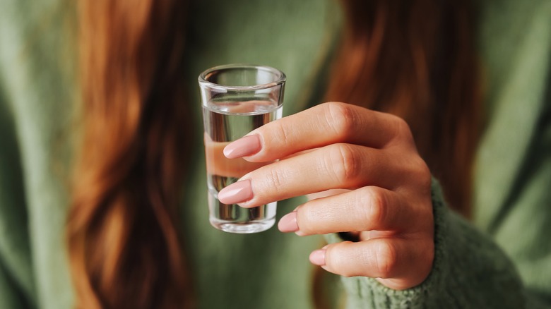 Woman holding a shot glass of vodka