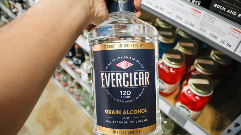 Hand holding bottle of Everclear in grocery store