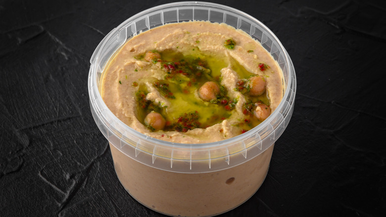 Container of hummus with toppings 